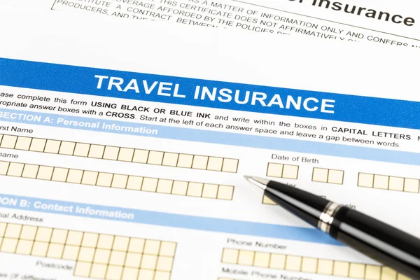 Formulário de pedido de seguro de viagem com caneta — Fotografia de Stock