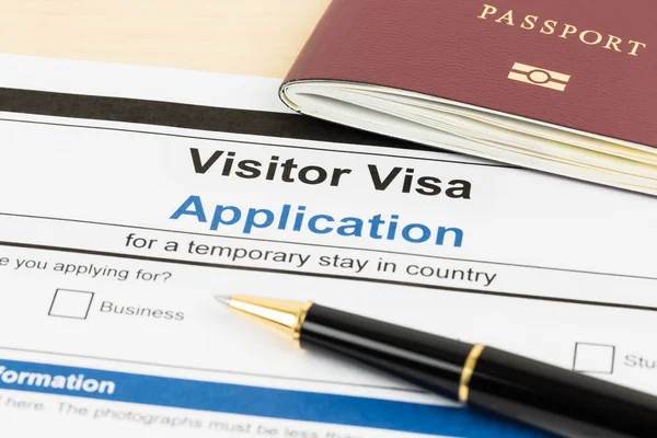 Formulario de solicitud de visado con pasaporte y pluma — Foto de Stock