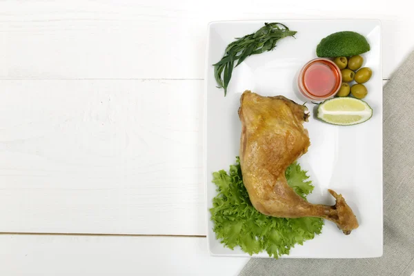 Coscia di pollo fritta su un piatto sul tavolo bianco — Foto Stock