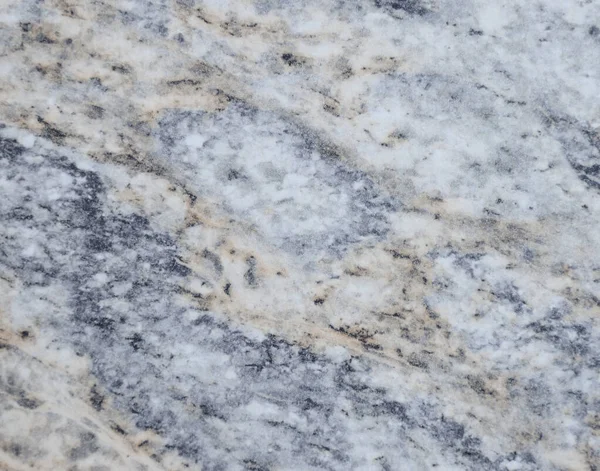Gray granite, flat surface of natural stone interspersed with black and beige veins. Background, texture.
