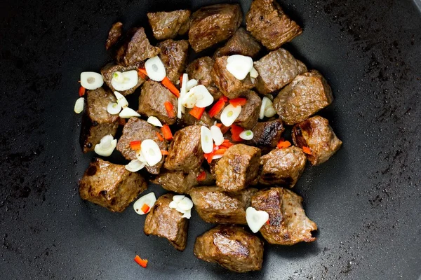 Cocinar plato de carne tradicional, carne frita en sartén con ajo y —  Fotos de Stock