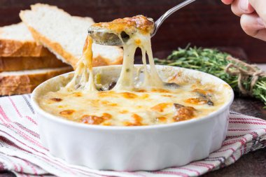 Mushrooms gratin with cream, cheese, French dish julienne clipart