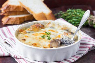 Mushrooms gratin with cream, cheese, French dish julienne clipart