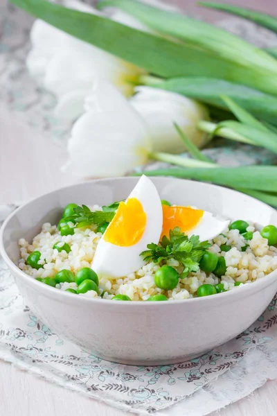 Bulgur, rice with green peas and boiled egg yolk, spring, summer — Stock Photo, Image