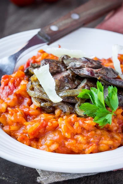 Tomato risotto, red rice with fried chicken liver, onions, Itali — Stock Photo, Image