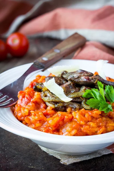 Tomato risotto, red rice with fried chicken liver, onions, Itali — Stock Photo, Image