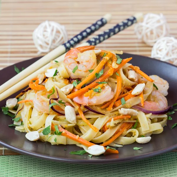 Fideos asiáticos con camarones, verduras, zanahorias, cacahuetes, cebollas , —  Fotos de Stock