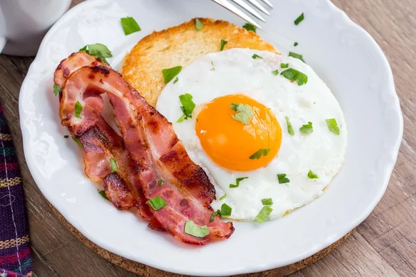 Petit déjeuner anglais classique, œufs frits, bacon, pain croquant, thé — Photo