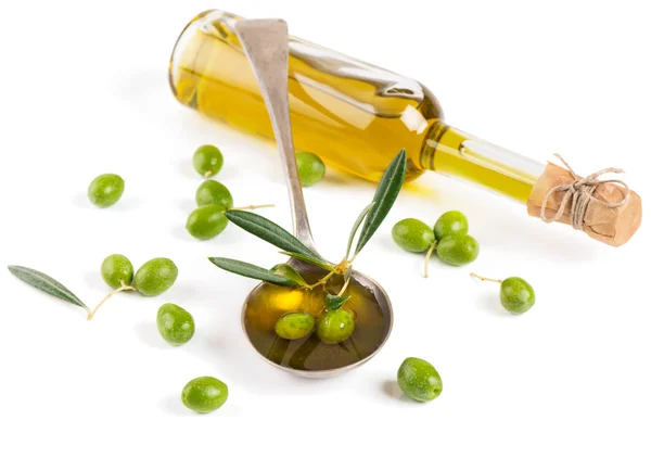 Aceite de oliva en una botella de vidrio y aceitunas verdes — Foto de Stock