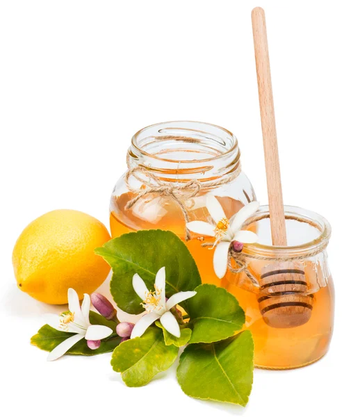 Glazen potten van citroen honing met bloemen — Stockfoto