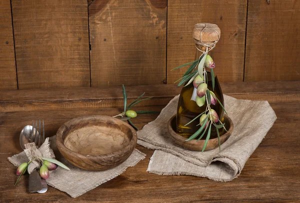 Bottiglia di olio d'oliva, olive fresche e stoviglie su legno antico — Foto Stock