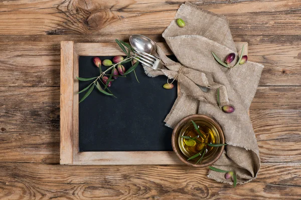 Vista aérea de un aceite de oliva con ramita de oliva y servilleta de lino —  Fotos de Stock