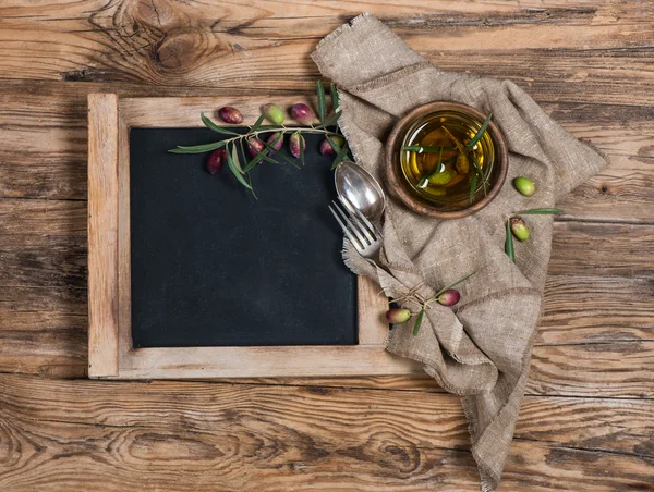 Vista superior de pizarra, vajilla y aceitunas con aceite de oliva —  Fotos de Stock