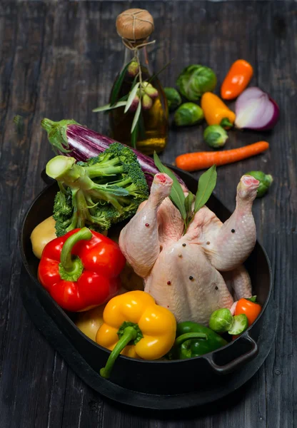 나무 탁자 위에 야채를 얹은 생닭 — 스톡 사진