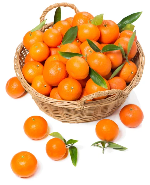 Mandarins with green leaves in a wicker basket — Stock Photo, Image