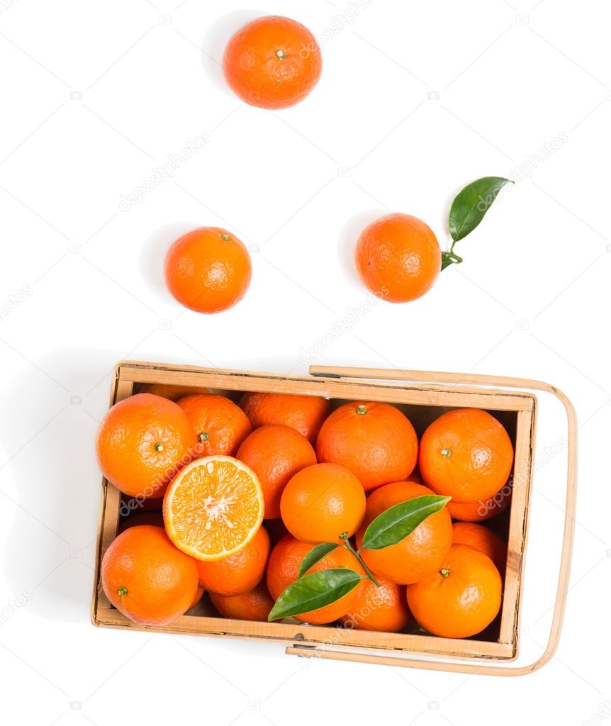 Crate of ripe tangerines with leaves, top view