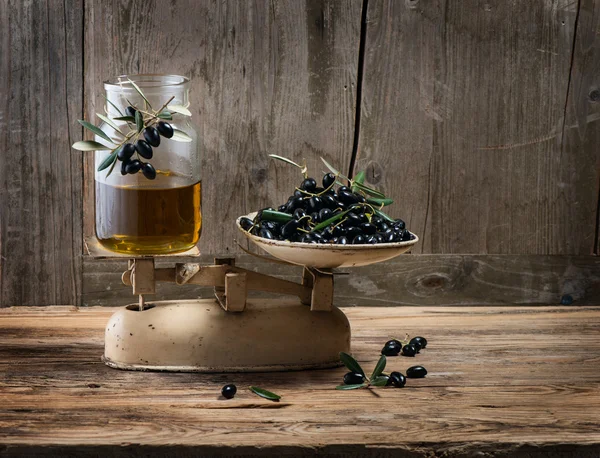 Old-fashioned balance scale with olives and olive oil — Stock Photo, Image