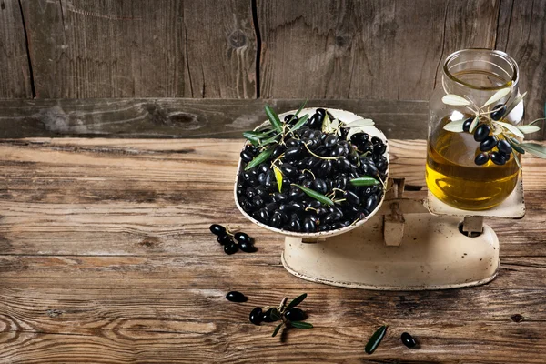 Balance scale fresh olives and olive oil — Stock Photo, Image