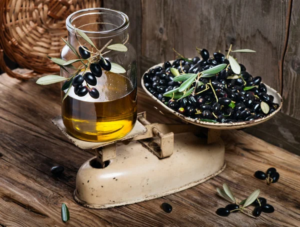 Balance scale fresh olives and olive oil — Stock Photo, Image