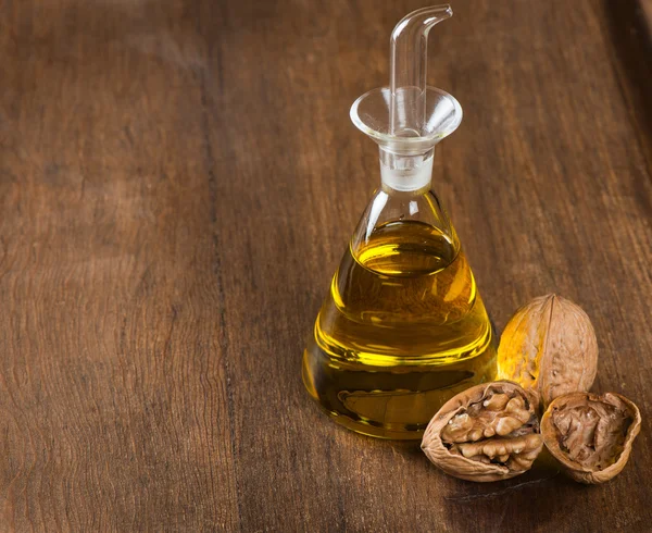 Walnussöl und Nüsse auf Holztisch — Stockfoto