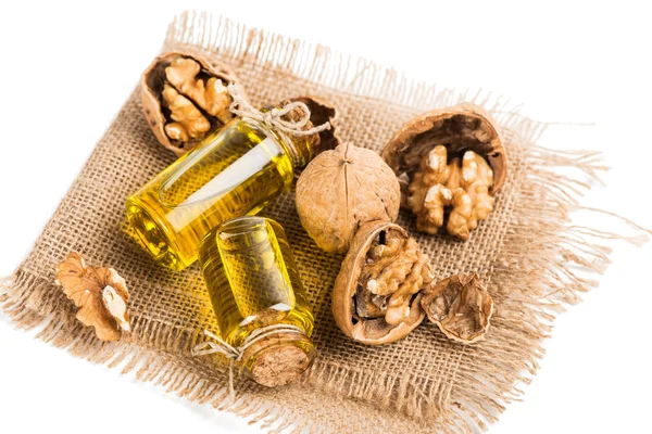 Olej z vlašských ořechů v malé láhve a ořechy — Stock fotografie