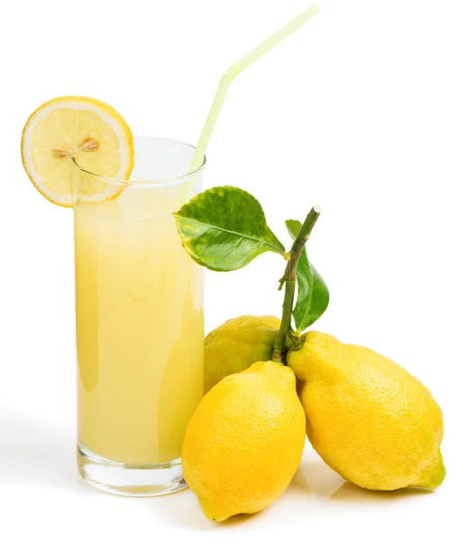 Glass with lemon juice, lemons — Stock Photo, Image