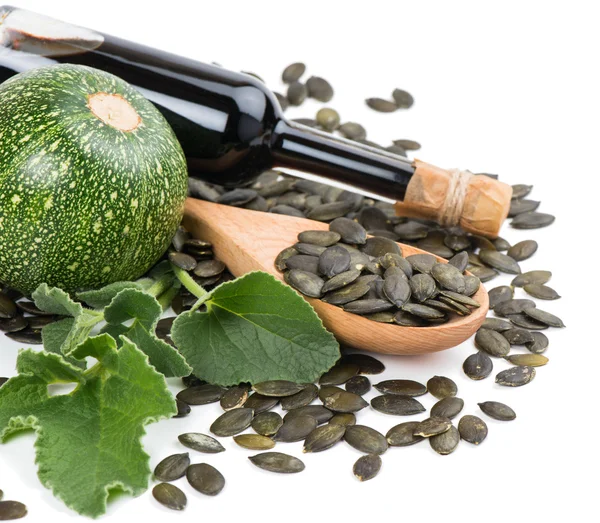 Glass bottle of Pumpkin Seed Oil, pumkin and peeled pumpkin see — Stock Photo, Image