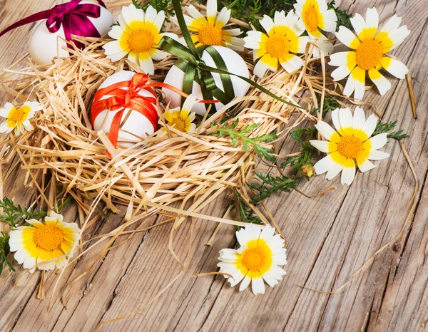 Pasen eieren in het nest met bloemen — Stockfoto