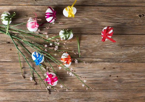 Easter eggs and branch with spring flowers, top view — Stock Photo, Image