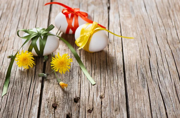 Easter eggs with bows over wooden  background — Stock Photo, Image