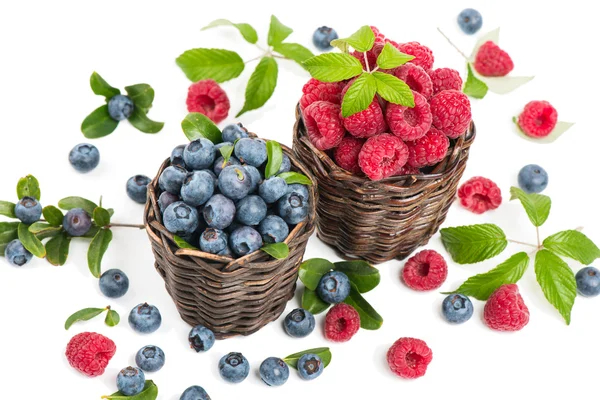 Blueberry and raspberry with leaves in a baskets — Stock Photo, Image