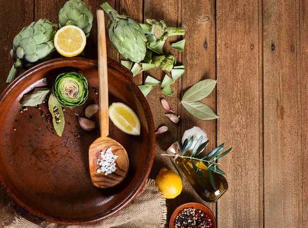 Raw ingredients ready to prepare baked artichokes, top view — Stock Photo, Image