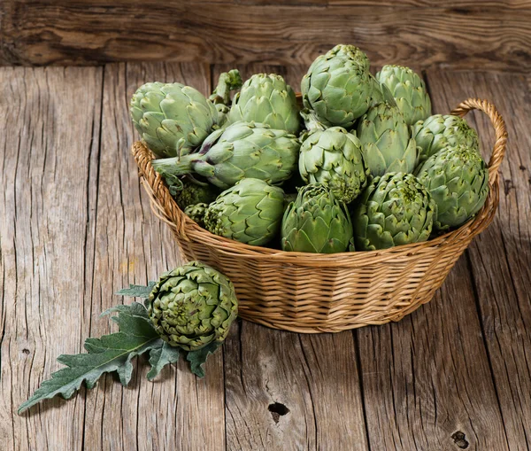 Großer Weidenkorb mit frischen Artischocken — Stockfoto