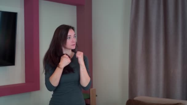 Mladá dívka hospodyňka v agresivním stavu box doma ve vzduchu ve zpomaleném filmu. — Stock video