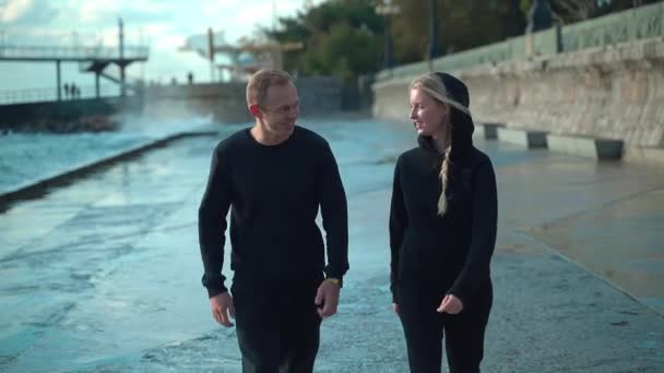 Una Joven Pareja Ropa Deportiva Está Caminando Cerca Del Mar — Vídeo de stock