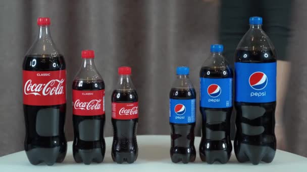 Jalta, Rusko, 29-November-2020-Pepsi vs Coca Cola. Tři nízko-litrové láhve Pepsi a Coca-Cola na stole dívka vybere Pepsi. — Stock video
