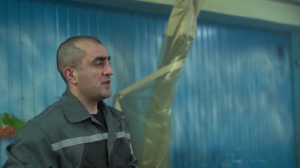 Portrait d'un homme caucasien dans un service de lavage de voiture parler à quelqu'un décide des moments de travail. — Video
