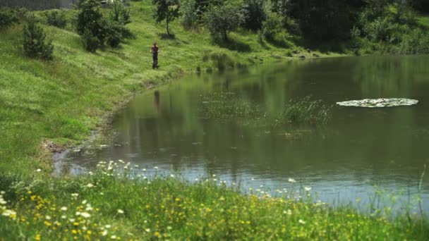 Οδηγώντας ένα ισχυρό ηλεκτρικό όχημα. Ένας άνδρας σε ένα κράνος ασφαλείας βόλτες το μονοπάτι σε ένα ηλεκτρικό σκούτερ κατά μήκος της λίμνης με την κάμερα — Αρχείο Βίντεο