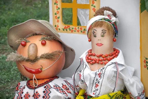 A married couple in their national costumes. The product,  vegetables at the fair. — Stock Photo, Image
