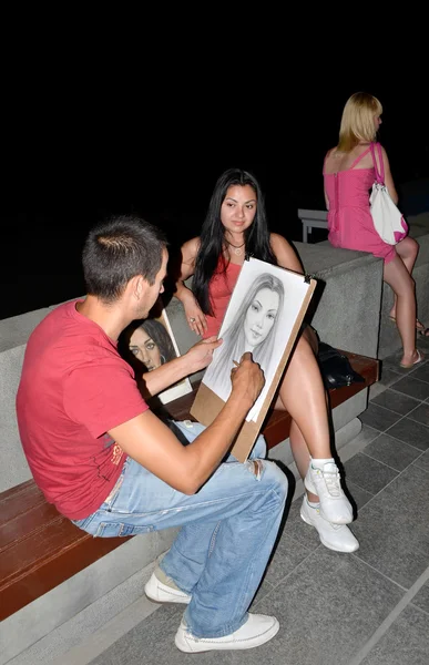 Sanatçı Crimea'da Yalta dolgu üzerinde güzel bir kadın portresi boyar. Meslek, meslek. Yalta, Kırım'da, 12 Ağustos 2012 — Stok fotoğraf