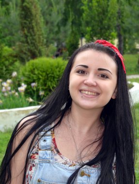 Young, beautiful girl, brunette with a red scarf. Fashion, beauty.