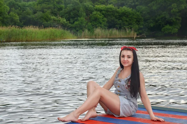 Erholung. junge schöne Frau, die allein am Ufer des Flusses sitzt. schöne Naturlandschaft. — Stockfoto