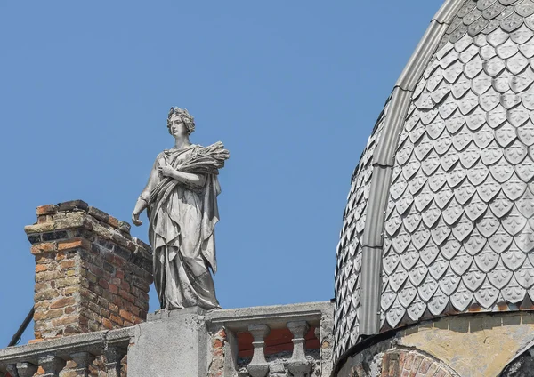 Standbeeld van een vrouw, de godin met een krans en oren van tarwe. Op het dak van het appartement gebouw in de stad van Odessa. — Stockfoto