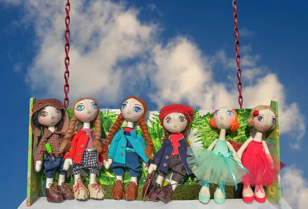 Dolls, toys ride on a swing against the blue sky. Novomoskovsk, Dnipropetrovsk region september 27, 2014 — Stock Photo, Image