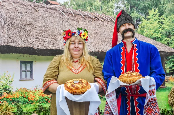 Hospitable man and woman in the Ukrainian national costumes. Novomoskovsk, Dnipropetrovsk region september 21, 2013 — Stock Photo, Image