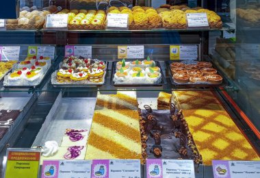 Mağaza vitrininde bol miktarda pasta, pasta ve kurabiye var. Her şey çok iştah açıcı görünüyor..