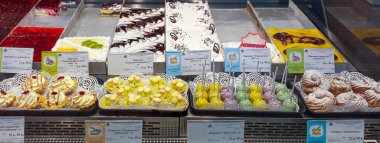 Mağaza vitrininde bol miktarda pasta, pasta ve kurabiye var. Her şey çok iştah açıcı görünüyor..