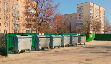 Çok katlı binaların bahçelerindeki özel konteyner alanlarının yakınlarındaki çöp tenekeleri ve çöpler..