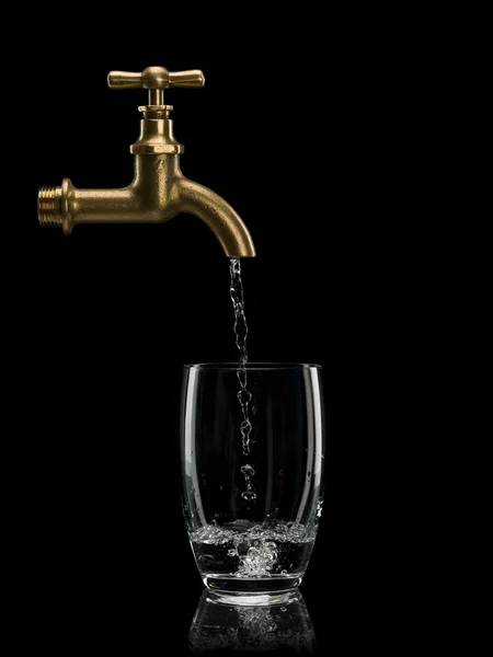 Filling by water of a glass from brass faucet — Stock Photo, Image