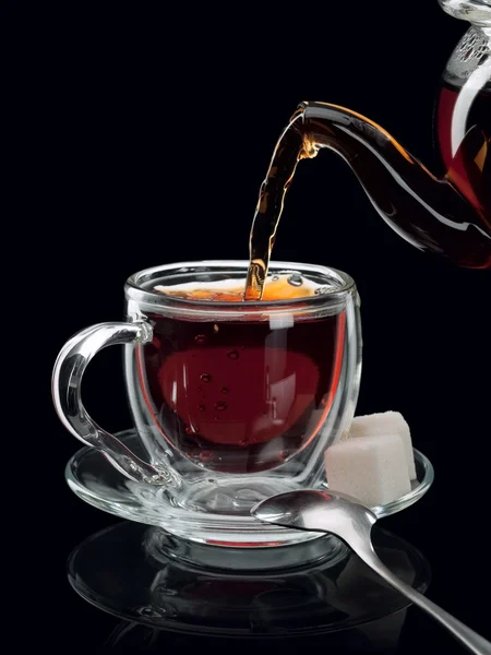 Fyllning av en glas kopp av te — Stockfoto